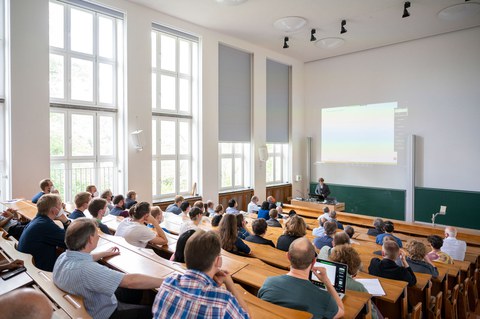 Viele Menschen sitzen in einem Hörsaal