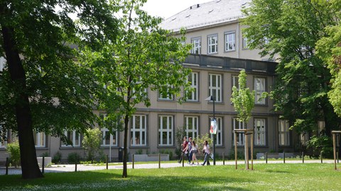 Studierende gehen am Physik-Gebäude entlang