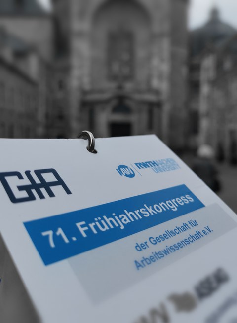 Das Bild zeigt einen Teilnehmer Ausweis der 71. GfA Frühjahrskonferenz vor dem Aachener Dom.