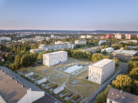 Das Foto zeigt eine Luftaufnahme der Gebäude der Sächsischen Landes- und Universitätsbibliothek. Zwischen den beiden Hauptgebäuden befindet sich eine große Grünfläche. Diese ist von einem Netzt aus kleinen Wegen durchzogen.