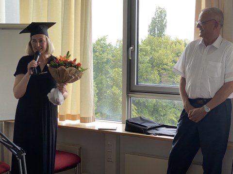 Rede von Dr. Rothländer (links) nach der erfolgreichen Promotion, mit dem Blumenstrauß