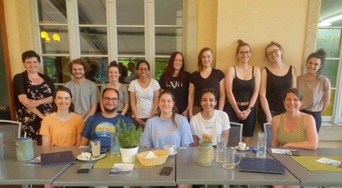 Gruppenfoto der Mitarbeitenden der Professur Kognitive und Klinische Neurowissenschaft. Die Mitarbeitenden befinden sich auf der Terrasse eines Restaurant und haben sich um einen Tisch versammelt.