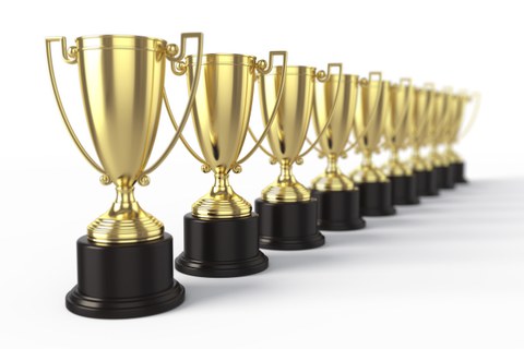 Es ist eine Reihe von mehreren goldenen Pokalen zu sehen