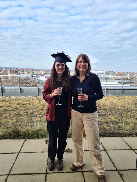 Lisa Jeschke trägt ihren Doktorhut und steht neben ihrer Betreuerin Prof. von Kriegstein