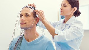 Foto einer Person, die ein EEG auf dem Kopf einer anderen Person anbringt