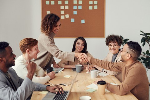 Gruppe von Menschen an Tisch sitzend