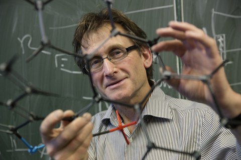 Ben Feringa, Chemie-Nobelpreisträger, hält ein Molekülmodell in die Kamera.