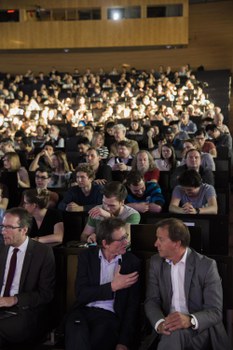 Ben Feringa sitzend vor den Zuschauerreihen im Gespräch mit Prof. Clemens Kirschbaum, Sprecher des Bereichs Mathematik und Naturwissenchaften