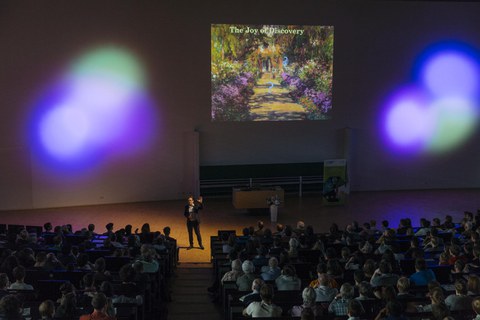 Ben Feringa bei seinem Vortrag vor erleuchteter Kulisse