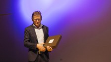 Ben Feringa bei seinem Vortrag vor erleuchteter Kulisse