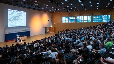 Blick von hinten über das Publikum zur Präsentation.