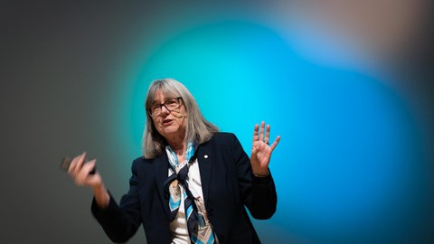 Donna Strickland bei ihrem Vortrag. Im Hintergrund bunte Beleuchtung.