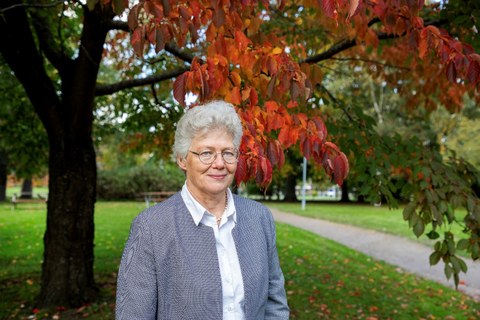 Prof. Anne L'Huillier steht vor einem Baum.