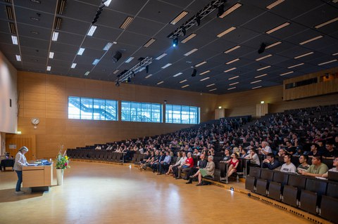 Prof. Dr. Angela Rösen-Wolff steht am Pult vorm vollen Audimax