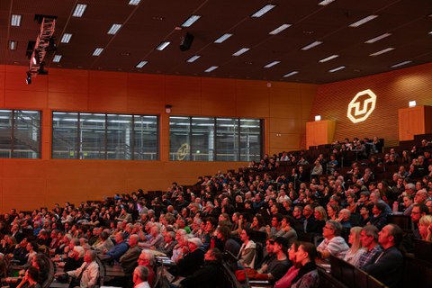 Bild des vollen Audimax- ein Strahler projiziert das TU Dresden Logo 