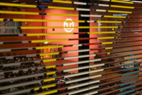 Foto von außen in den Audimax- es wird die Powerpoint von Reinhard Genzel vom Beamer an die Wand geworfen