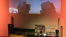 Foto von hinten über die Köpfe der Zuschauenden hinweg. Vorne sieht man die Powerpoint von Reinhard Genzel auf der er und ein Bild des "very large telescop"  zu sehen ist