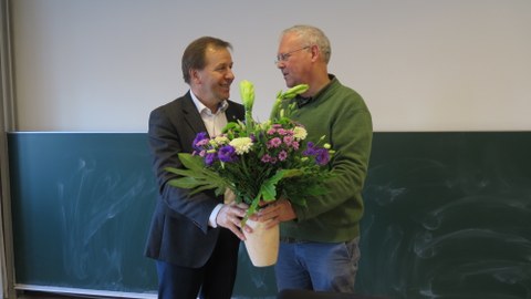 Prof. Kirschbaum bekommt Blumenstrauß von Prof. Neinhuis überre