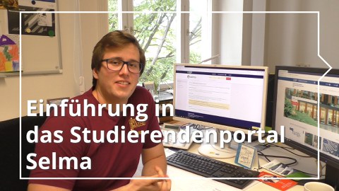 Ein Student sitzt am Schreibtisch vor zwei Bildschirmen.