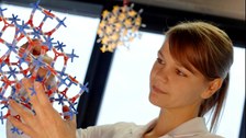 Frau mit Molekülstruktur in der Hand