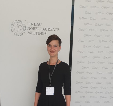 Janine Richter mit dem Logo der Lindauer Nobelpreistagung im Hintergrund.