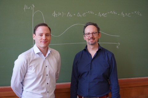 Felix Sachse links, Martin Keller-Ressel rechts, vor einer Tafel stehend