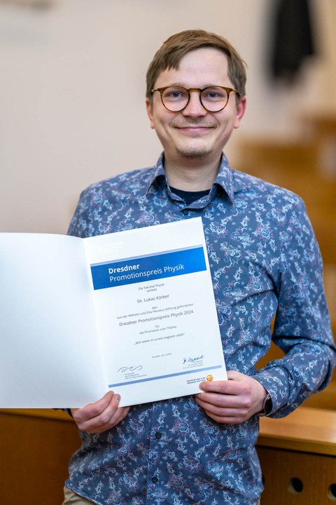 Dr. Lukas Körber mit der Urkunde zum Promotionspreis Physik.