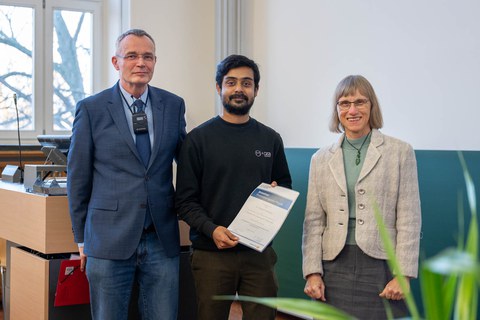 Drei Personen schauen in die Kamera.