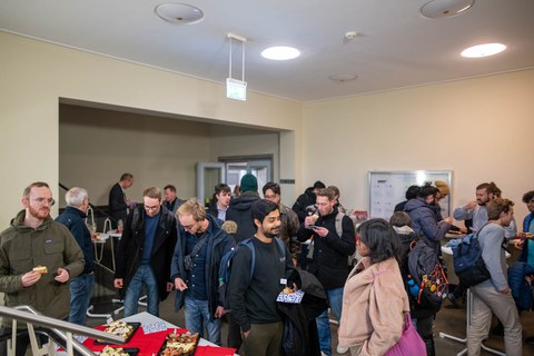 Leute sprechen miteinander im Foyer.