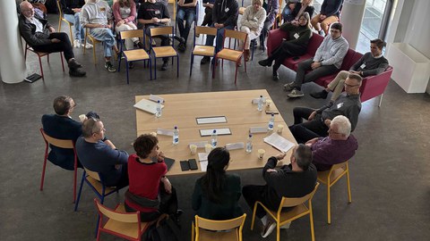 Personen sitzen um einen Tisch.