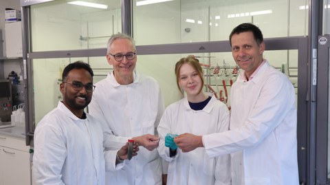 Vier Personen im weißen Kittel stehen im Labor.