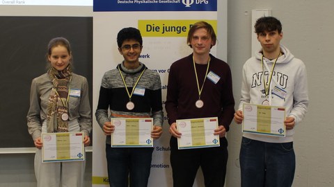 Vier Studierende mit einer Urkunde in der Hand.