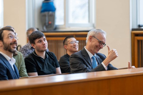 Mann in Hörsaal Reihe macht den Daumen nach oben