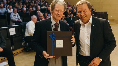 Sir Gurdon mit Prof. Kirschbaum und seinem Gastgeschenk aus Meißner Porzellan
