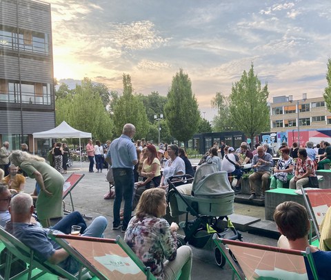 Menschenmenge vor dem Biologie Gebäude der TU Dresden. Viele sitzen auf Liegestühlen der SLUB. Die Sonne geht unter