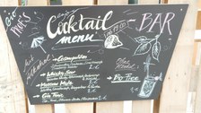 Auf einer Tafel steht das Cocktail Menü