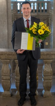 Hans Kleemann mit Blumenstrauß und Urkunde