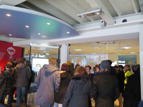 Die Studierenden werfen im Besucherzentrum des ATLAS-Detektors einen Blick in eine Kontrollzentrale.