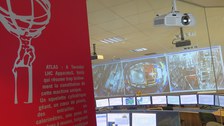 Im ATLAS-Besucherraum werfen die Studierenden einen Blick über die Schulter von Physikern einer Kontrollzentrale.