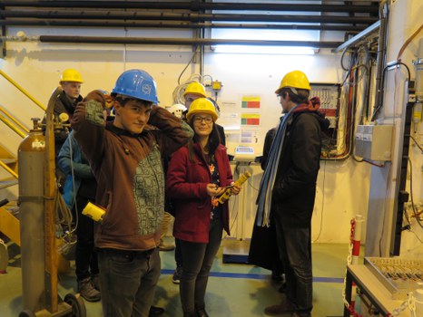 Studierende mit Bauarbeiterhelmen bereiten sich auf einen Rundgang vor.