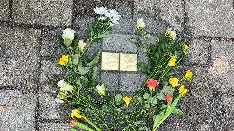 Zu sehen sind die Stolpersteine von Dr. Walter Blumenfeld und Magrgarete Blumendeld. Um die Steine  sind Schnittblumen gelegt.