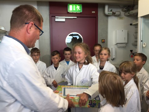 Der Leiter des Kinderlabors, Dr. Uwe Schwarzenbolz, zeichnet die 10-jährige Grundschülerin Josefine Bohn als 2.000 Teilnehmerin des Kinderlabors aus. 