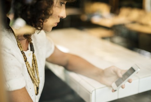 Eine Frau grübelt über ihrem Smartphone