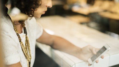 Eine Frau grübelt über ihrem Smartphone