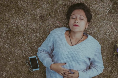 Eine Frau schläft tief, neben ihr ein Smartphone.