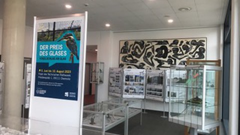 Bild der Ausstellung Preis des Glases. Man sieht  Teile der Ausstellung und das Plakat der Ausstellung