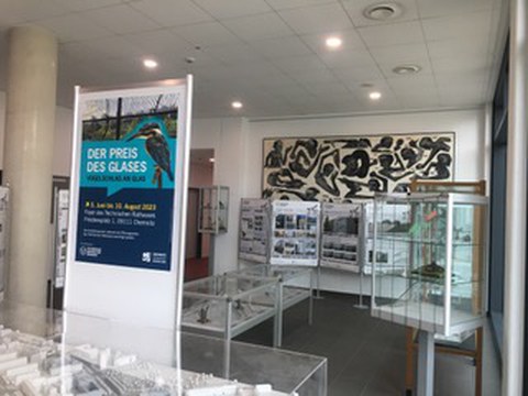 Bild der Ausstellung Preis des Glases. Man sieht  Teile der Ausstellung und das Plakat der Ausstellung