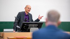Prof. Carsten Timm am Pult im Hörsaal.