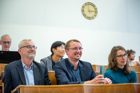 Gäste im Hörsaal mit fröhlichen Gesichtern.