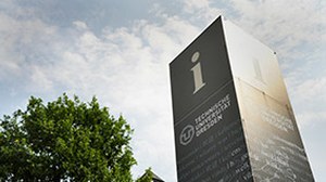 Das Foto zeigt eine Informationssäule der TU Dresden vor leicht bewölktem Himmel.